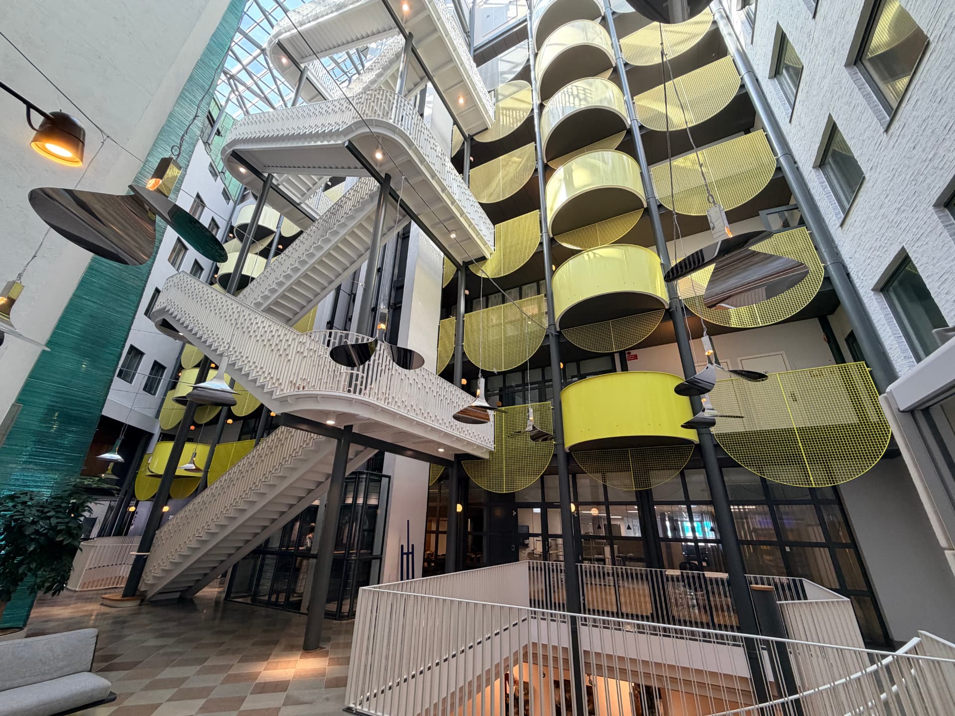 Modern atrium med trappramp och akustiktak i en offentlig byggnad